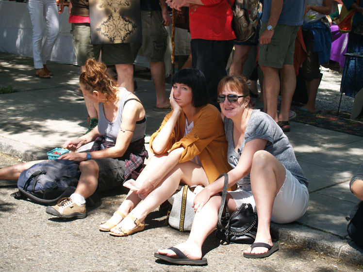 stylish duo sitting on curb