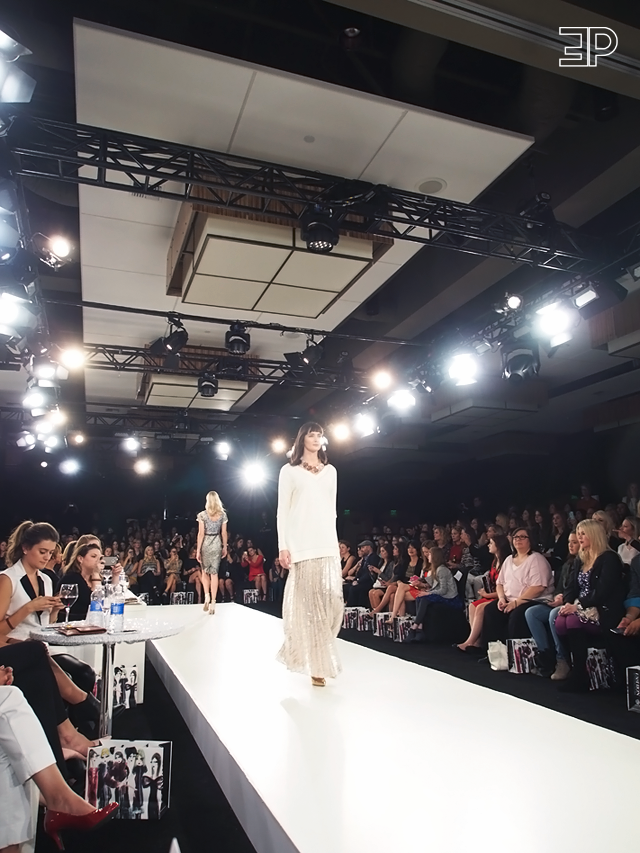 Oversized ivory sweater paired with a glimmering gold pleated maxi dress. Look from Bellevue Fashion Week in Seattle, WA