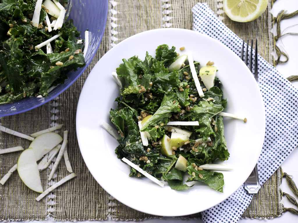 Tablescape shot of a power kale salad with almond butter salad dressing