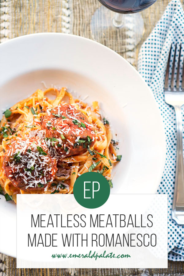 bowl of pasta with veggie meatballs with fork, napkin, and wine setting