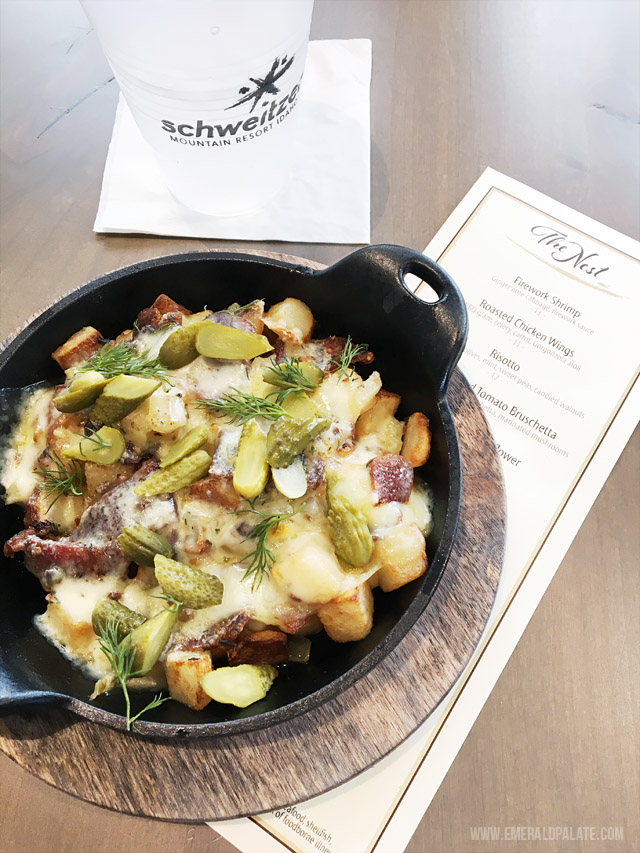 Raclette served with potatoes, bacon, cornichons, and dill. Served at The Nest on Schweitzer Mountain Resort, the lodge at the top of this popular ski resort.