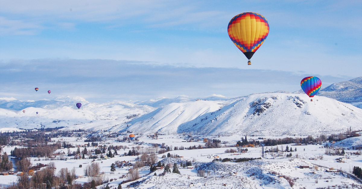 hot air balloons over snowy landscape at hot air balloon event