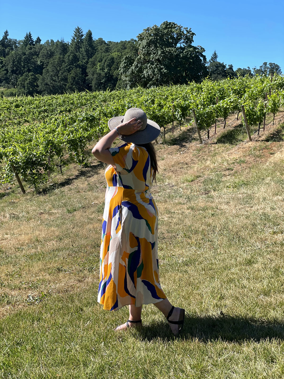 woman standing in front of vineyards
