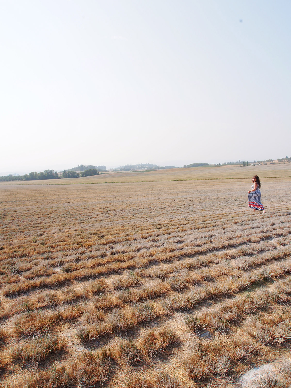 woman walking through farmland in Willamette Valley
