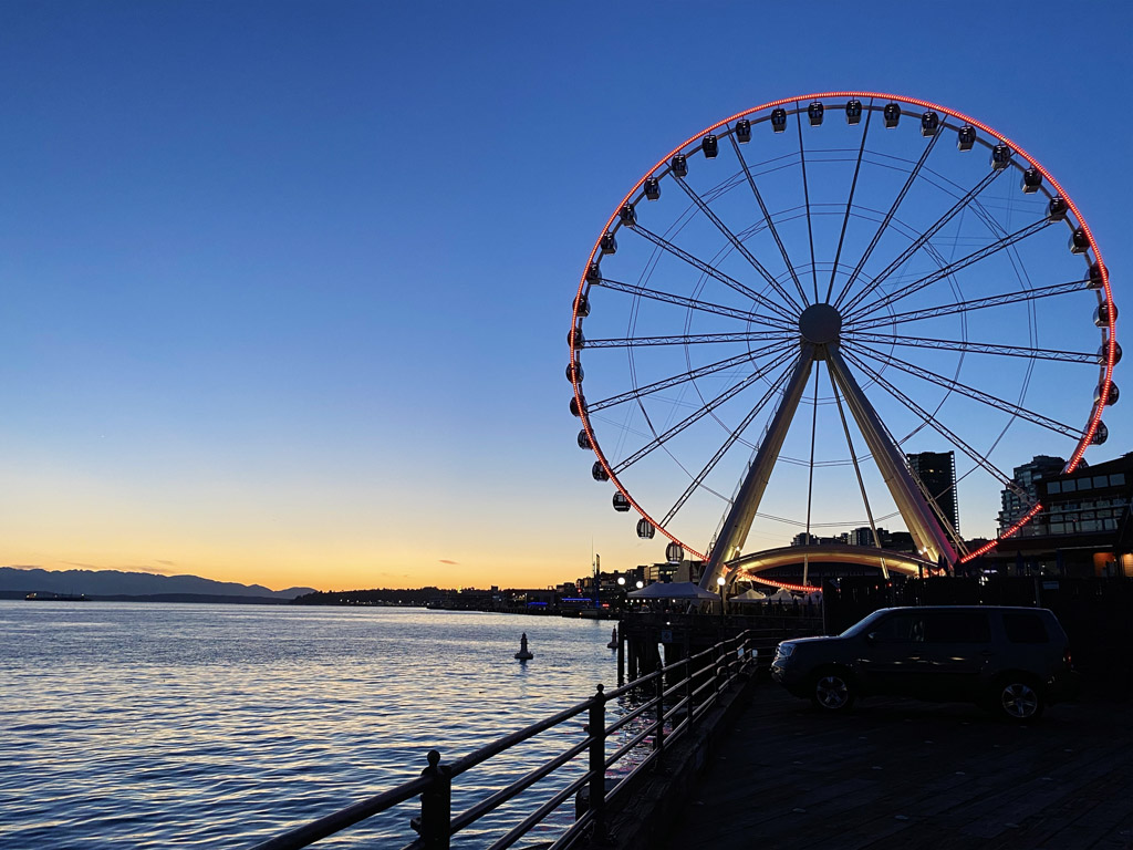 Ferris wheel next to the water at sunset, one of the best places to take pictures in Seattle