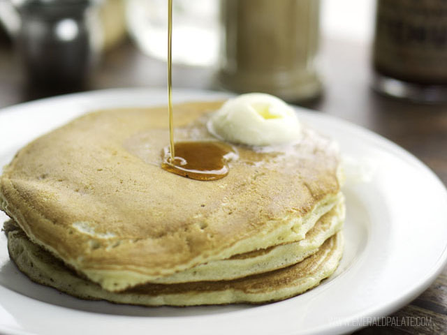 syrup being poured over pancake short stack