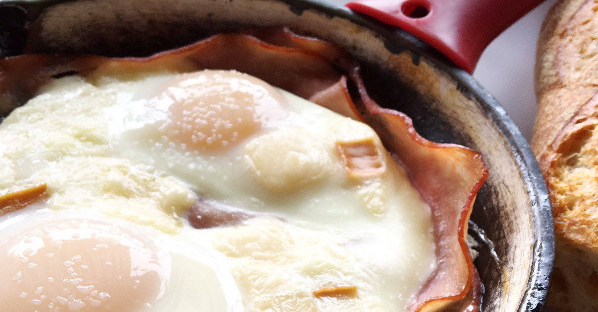 close up of a skillet with eggs and ham 