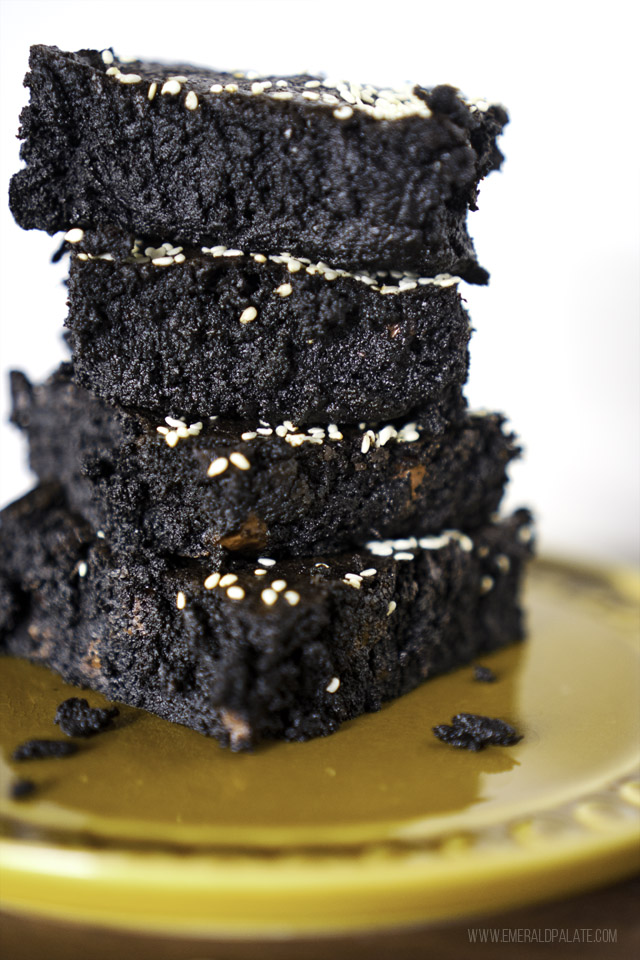 Close up of 4 stacked coconut banana fudge brownies with coconut oil and sesame seeds