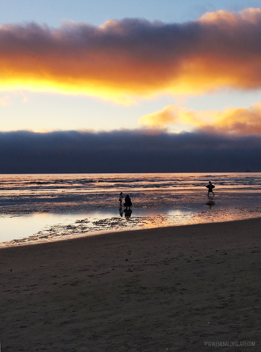 family playing in ocean at sunset on Cannon Beach, Oregon