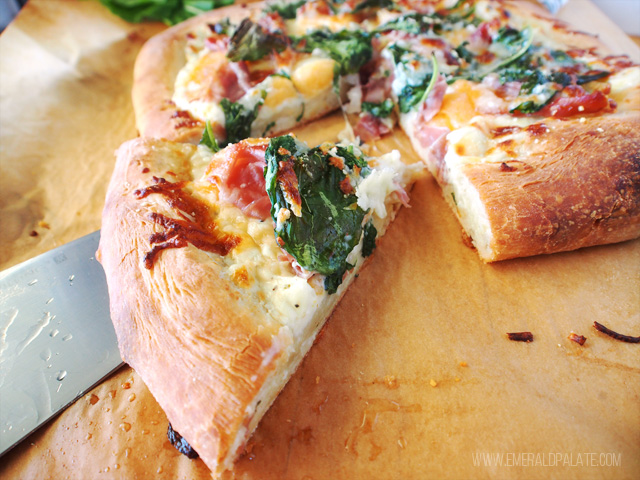 Close up of white pizza recipe with prosciutto, melon, and arugula