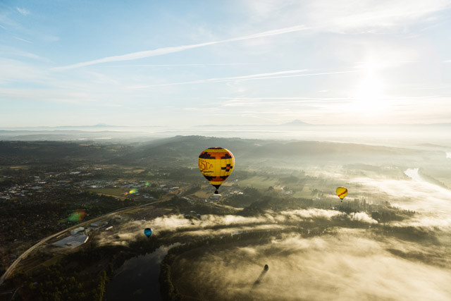 Hot air balloons gliding over the clouds and wineries in the Willamette Valley