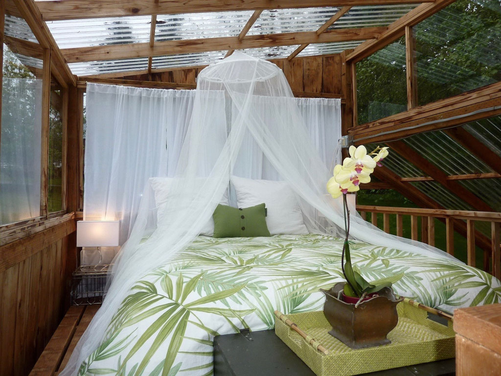 mosquito net over a bed in a greenhouse