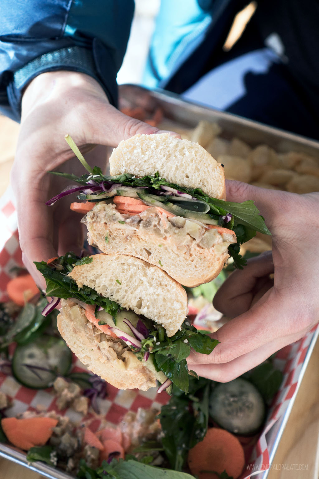 person holding stack of sandwich halves 