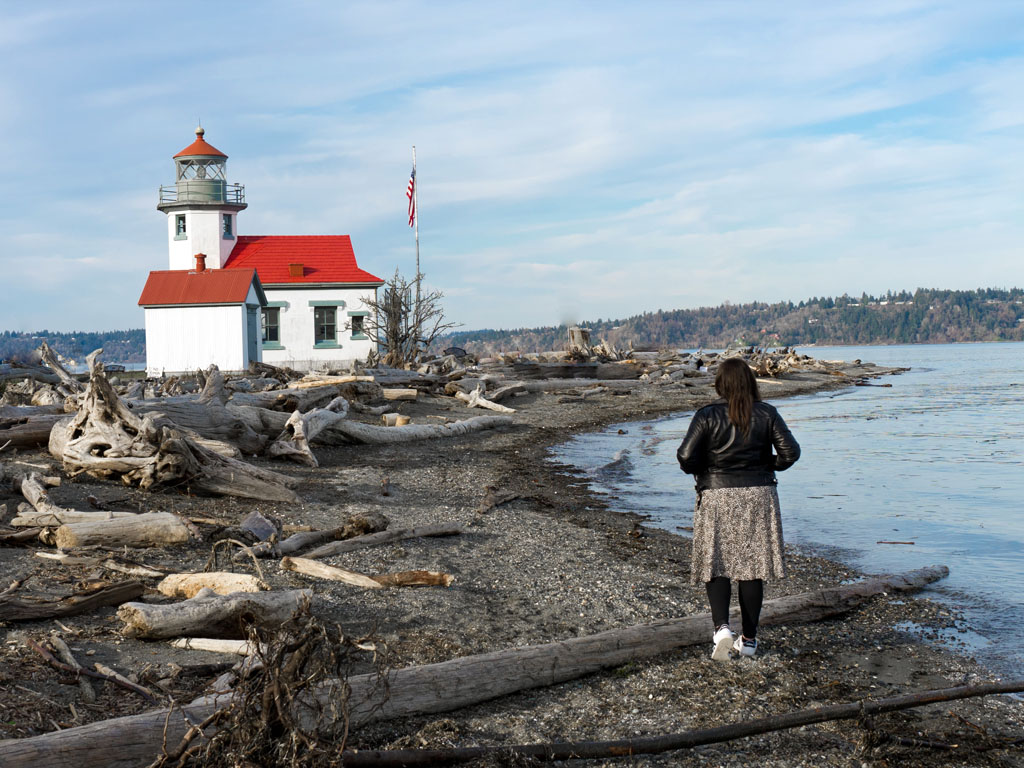 woman walking along beach at Point Robinson State Park, a thing to do on Vashon Island, WA