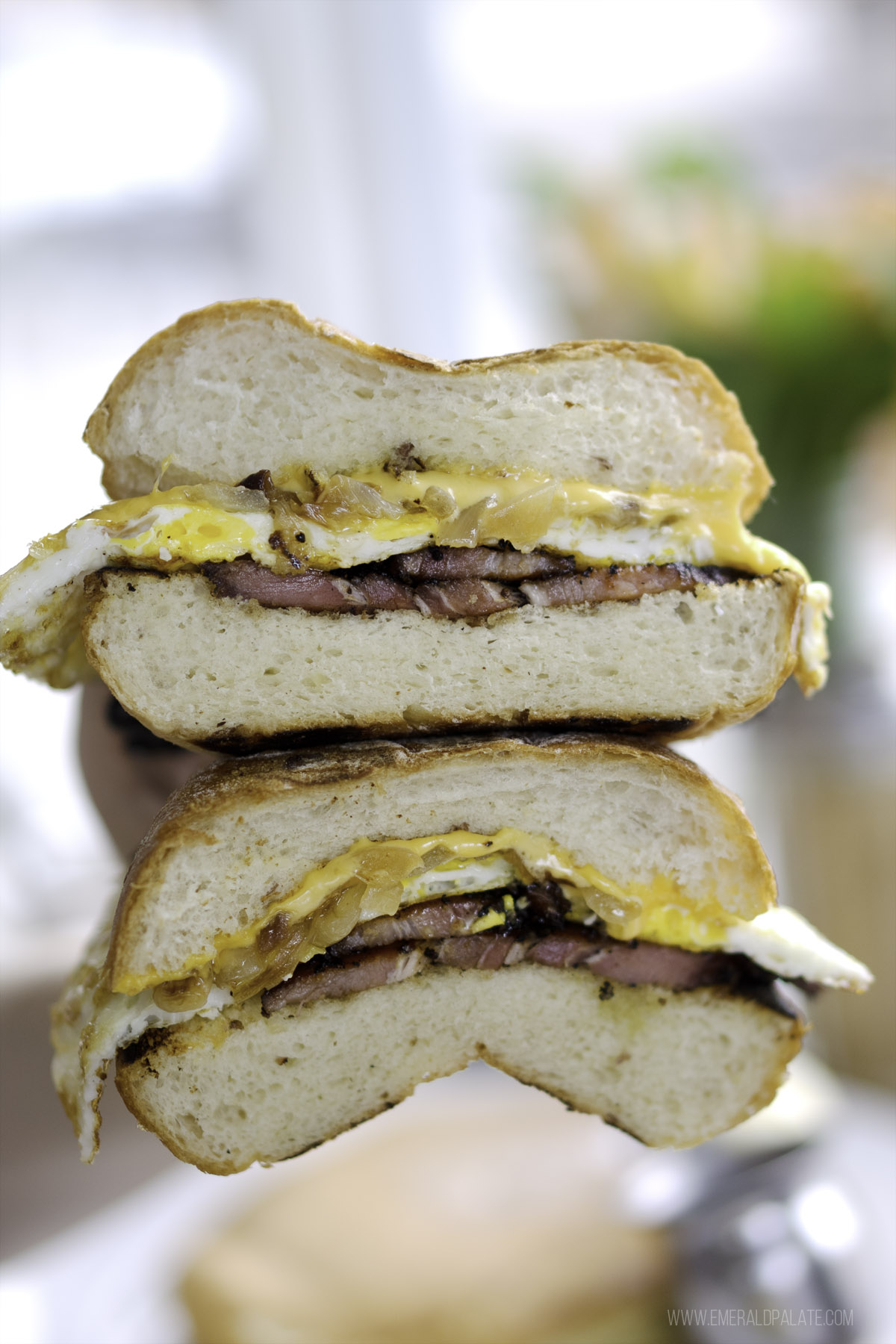 person holding two halves of a breakfast sandwich on top of each other