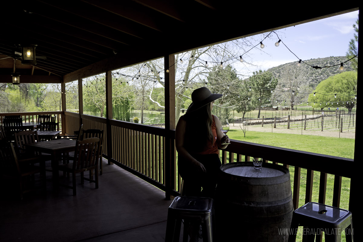 woman enjoying wine on a covered patio of a winery