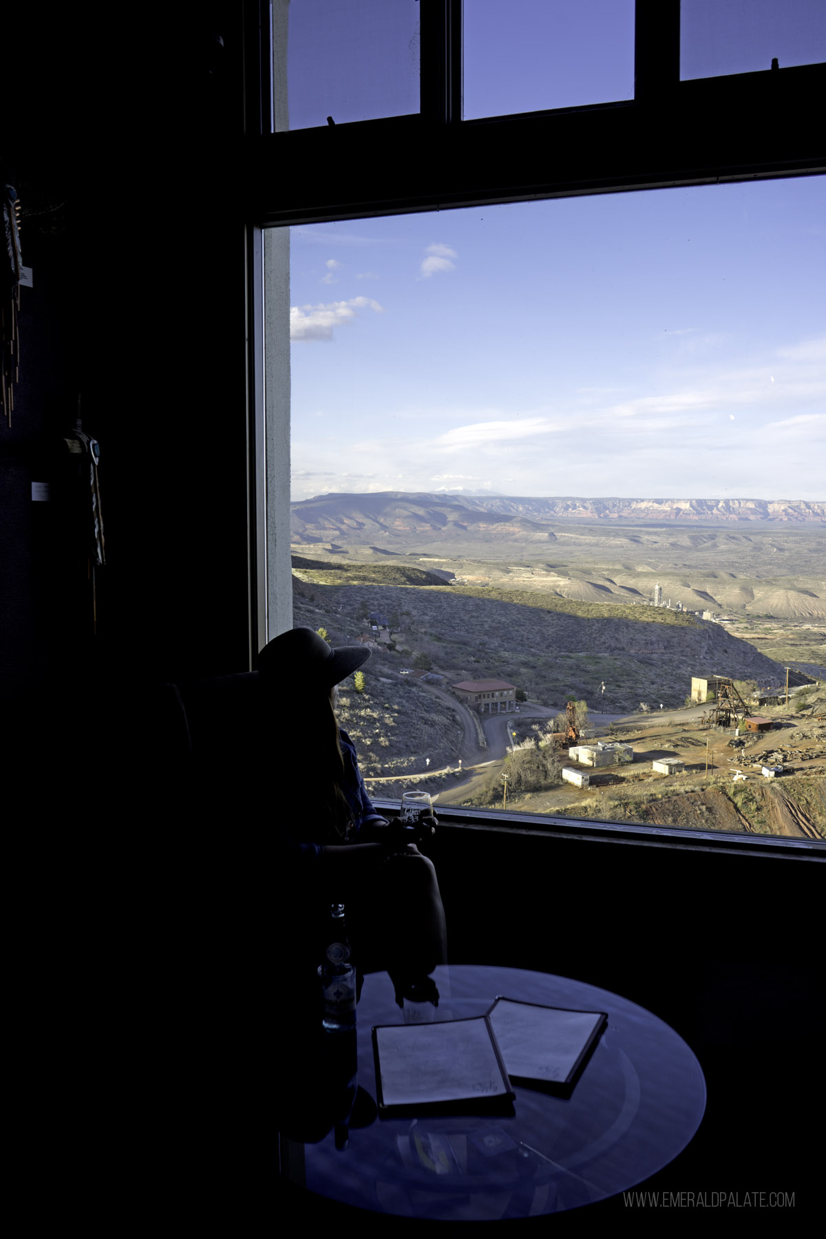 woman looking out a picture window over beautiful Arizona landscape at one of the best wineries in Jerome, AZ