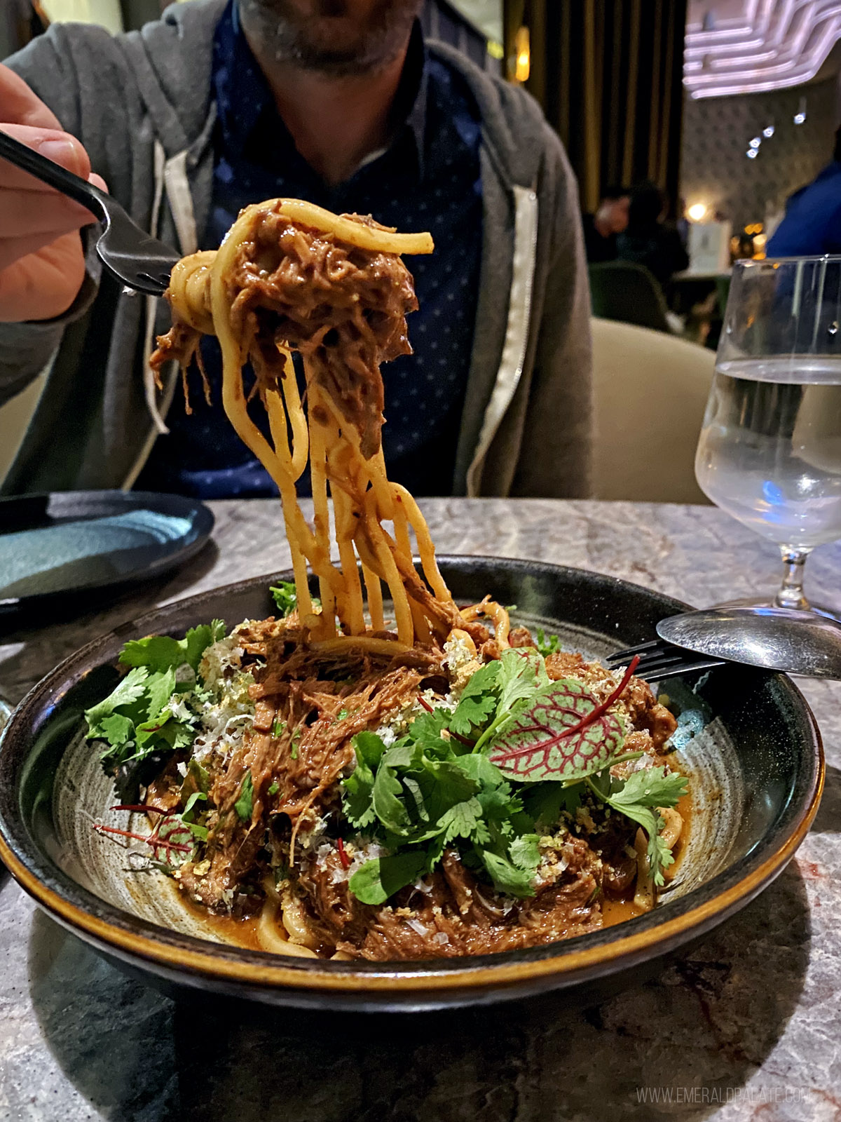 person picking up noodles at a San Diego restaurant