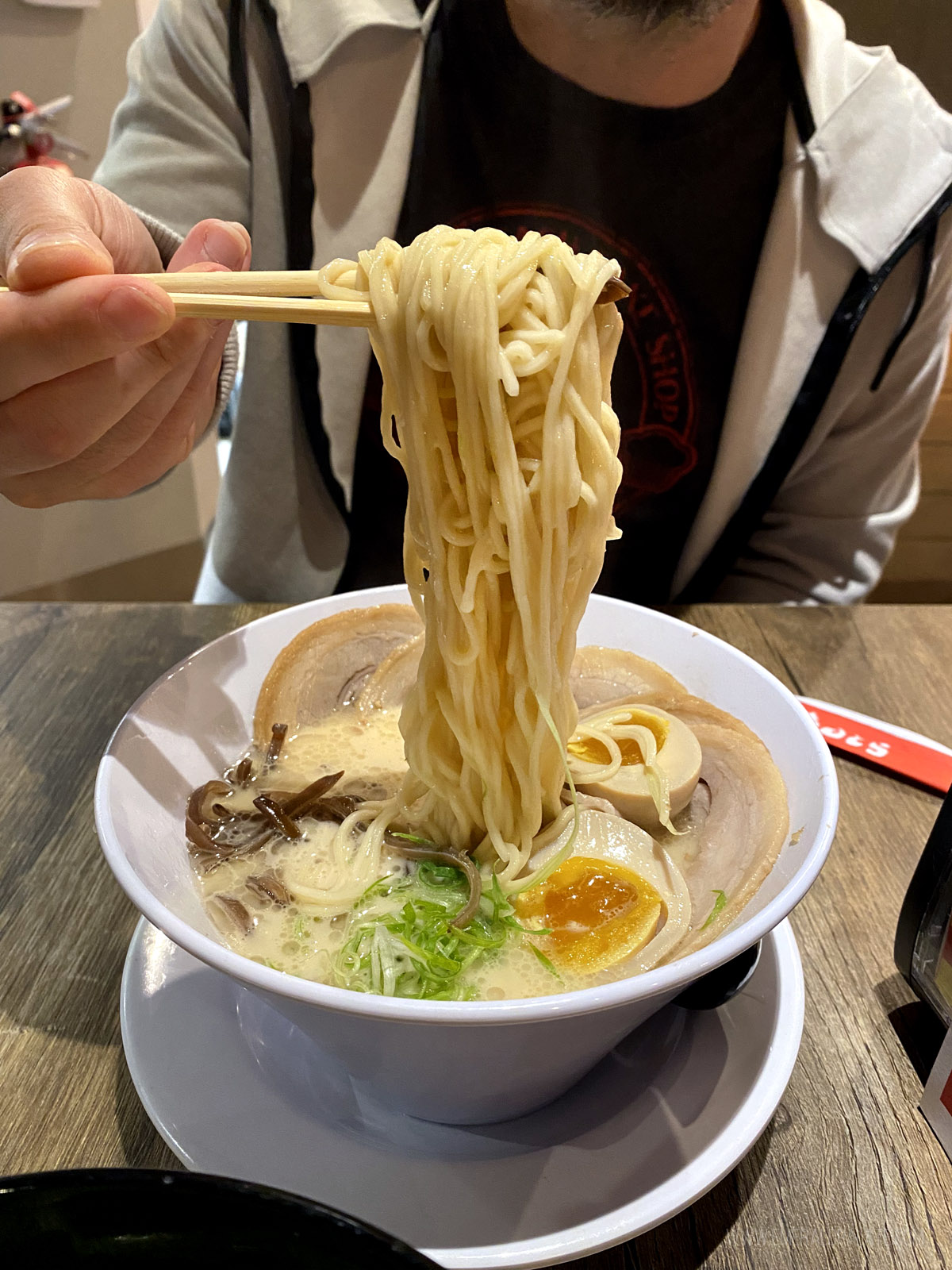 person picking up noodles in a bowl of ramen from one of the best hidden gem restaurants in San Diego