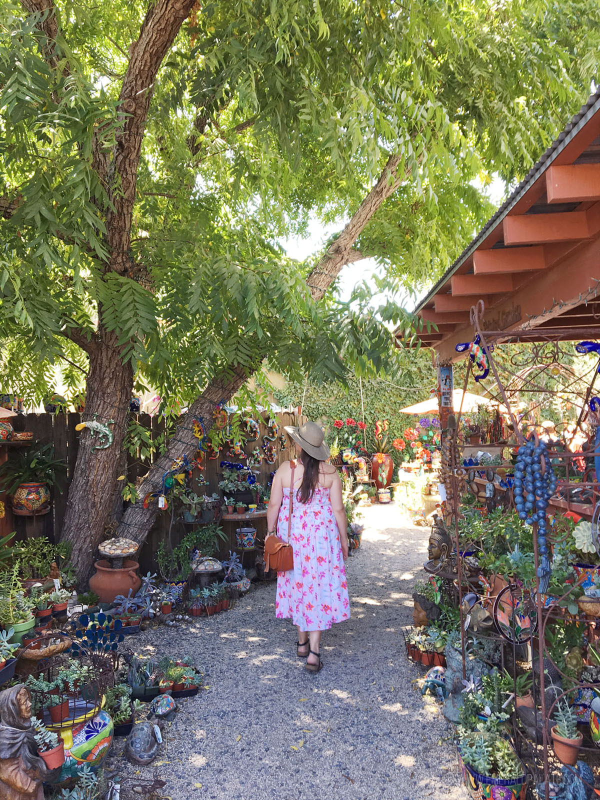 woman walking through trees at a sculpture garden