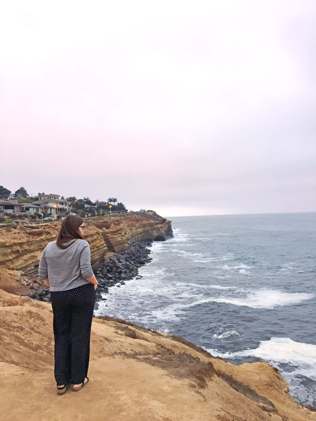 woman overlooking the water at Sunset Cliffs, a must visit on your  3 day San Diego itinerary