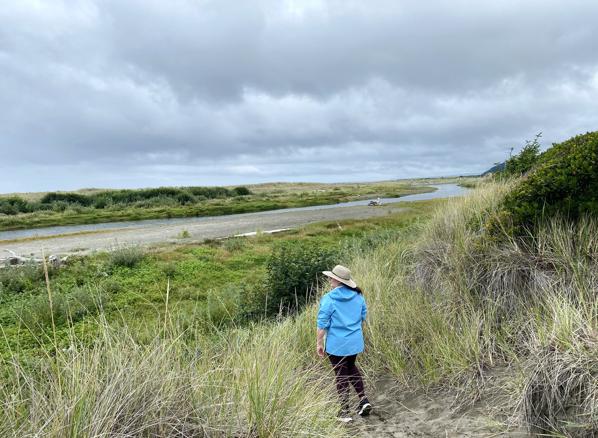woman overlooking a marshy grassland on the Washington coast