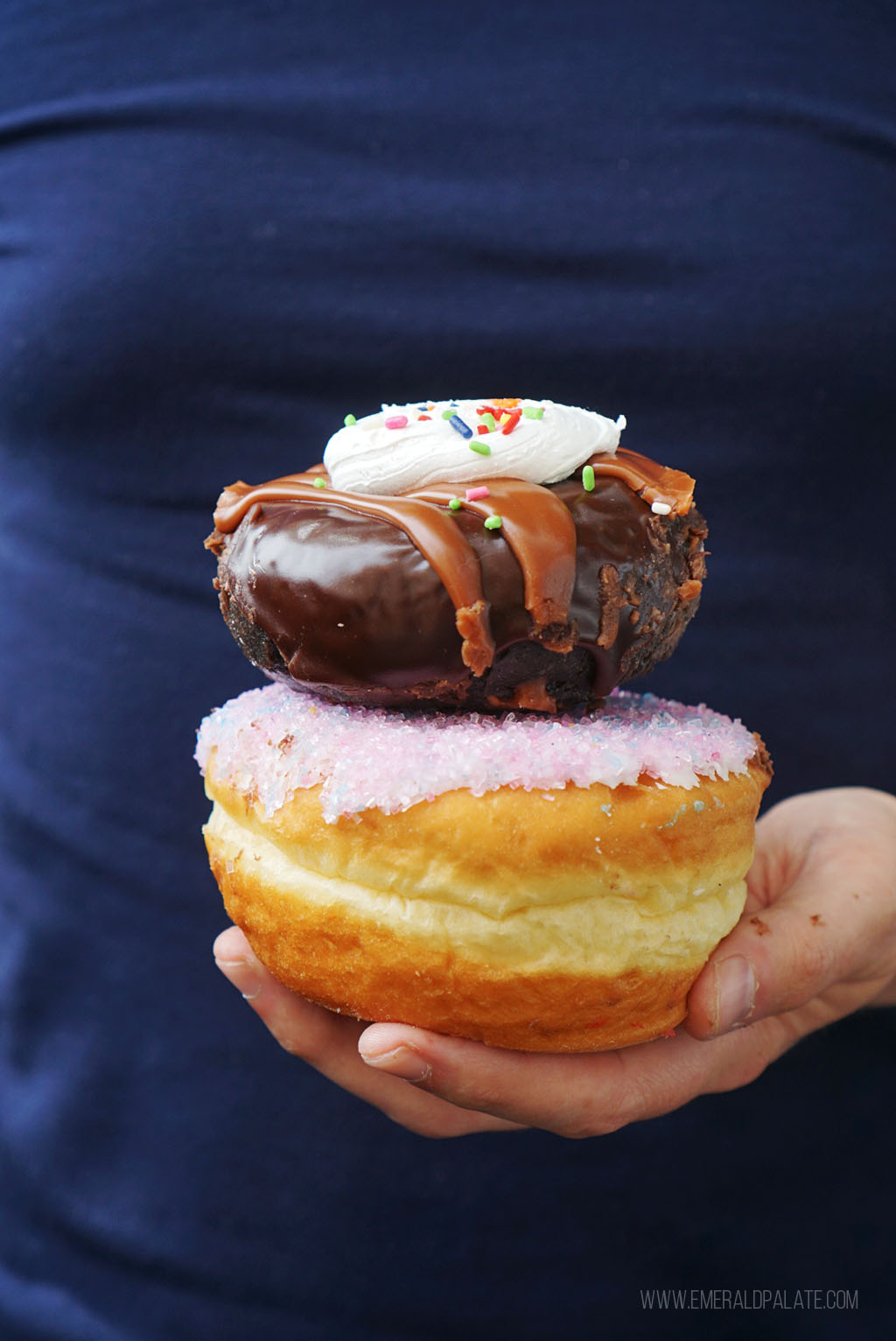 person holding a stack of doughnuts, some of the best food in Tacoma, WA