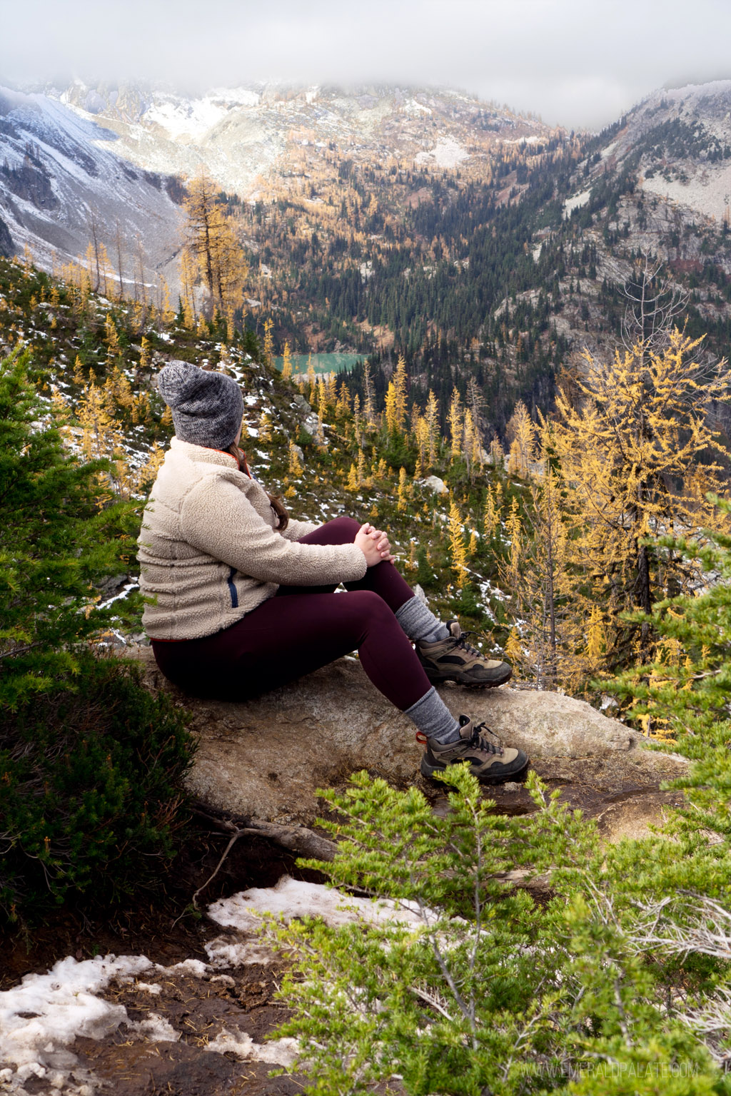 woman overlooking larches and an alpine lake on one of the best larch hikes in Washington