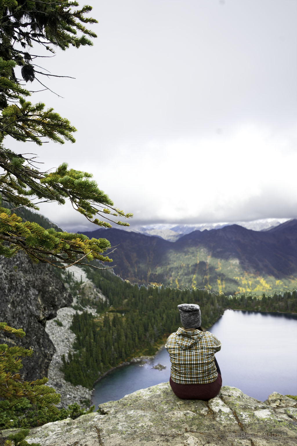 woman looking over a lake on one of the best larch hikes