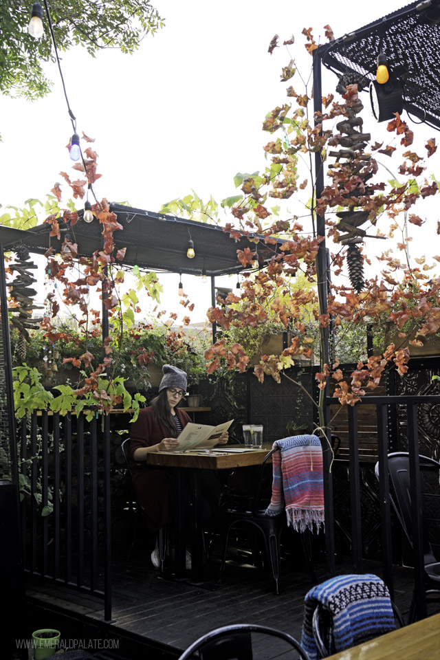 Adria of The Emerald Palate sitting in the lush outdoor patio at McGlinn's Public House, one of Wenatchee, WA restaurants