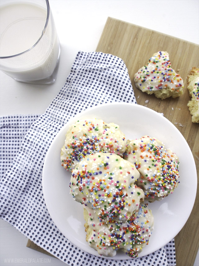 cookie with rainbow sprinkles, icing, and served with milk