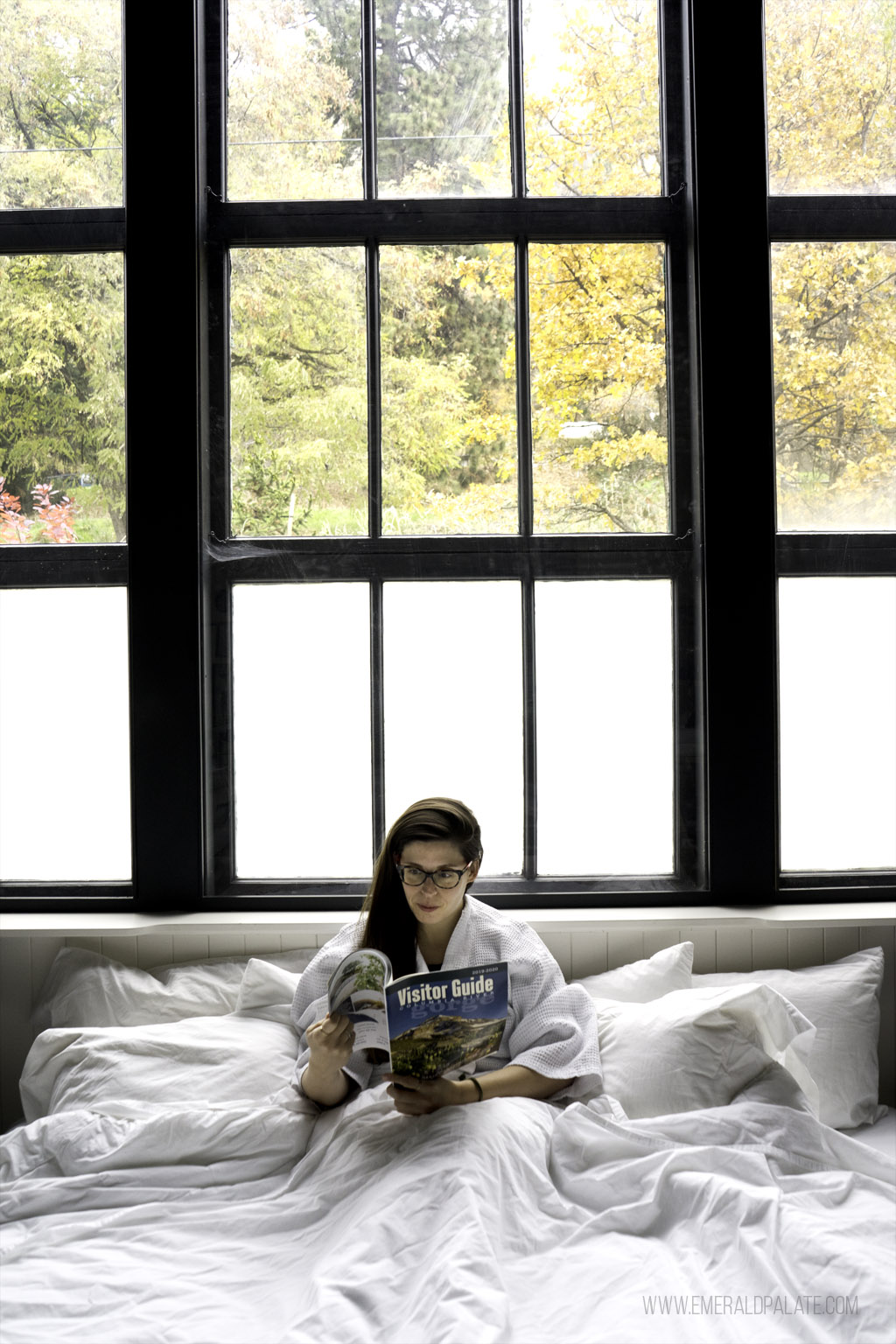 woman reading in bed at a hotel in Columbia River Gorge