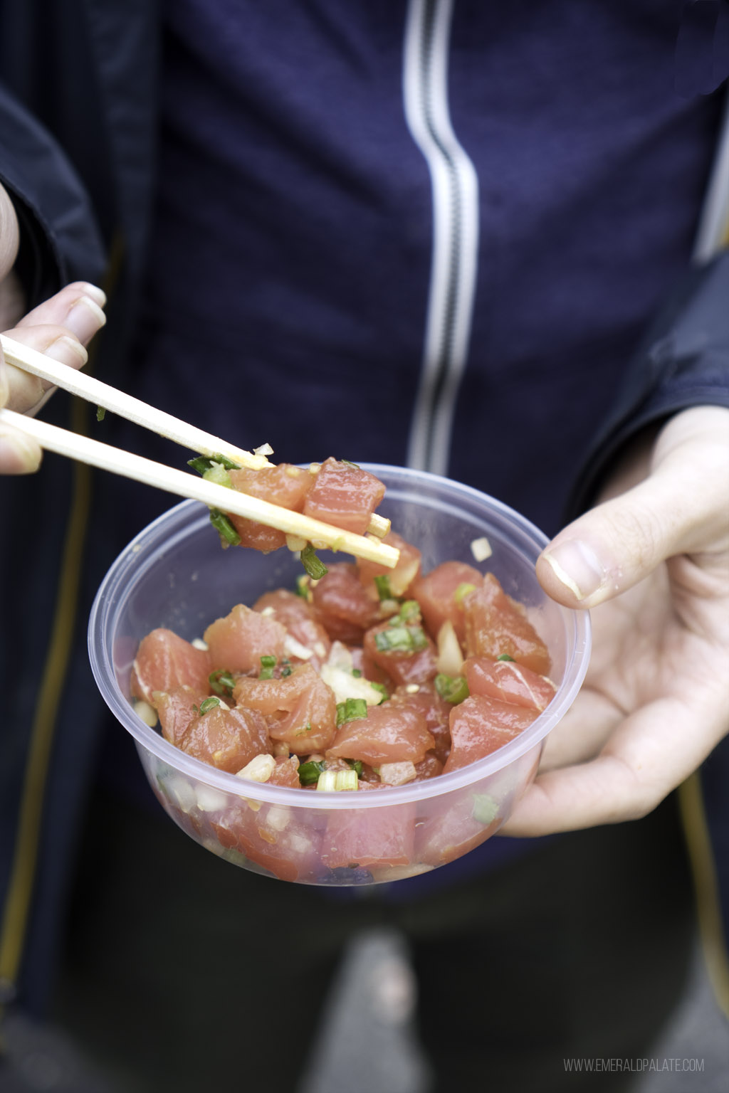 person picking up poke at one of the best Edmonds restaurants