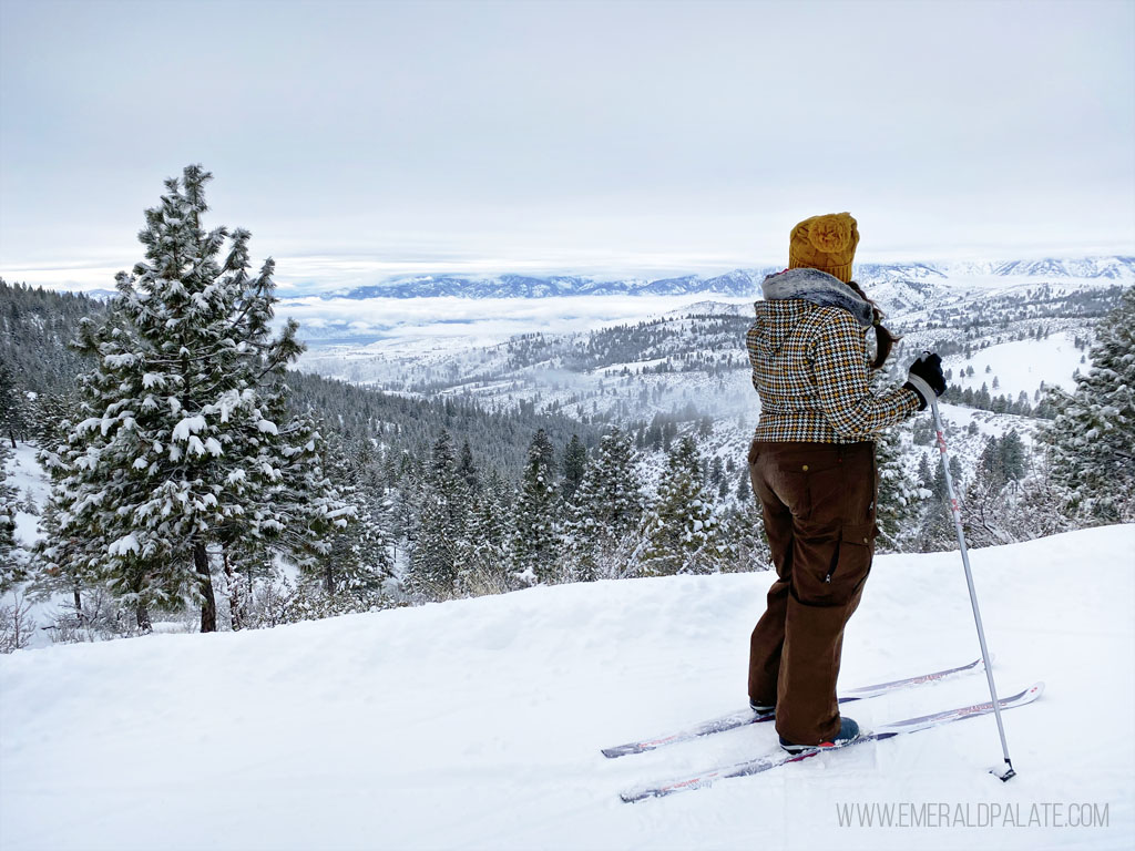 woman cross-country skiing on a ridge overlooking Lake Chelan, one of the best road trips from Seattle