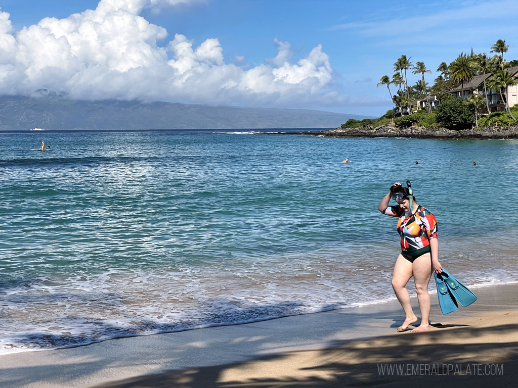 woman walking along Maui beach with snorkel equipment during a 5 day Maui itinerary