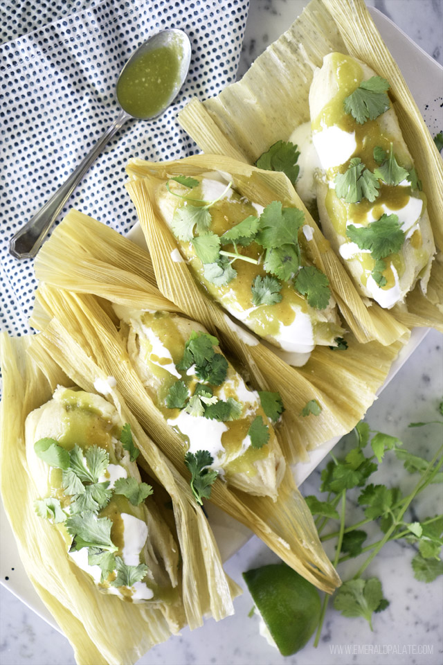 tamales on a platter with their husk open