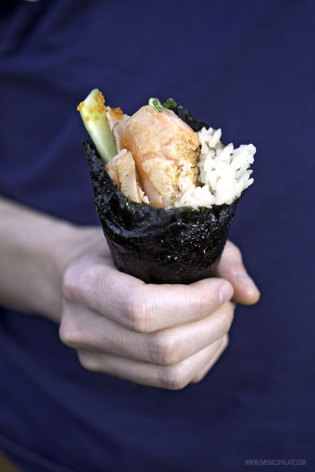 close up of salmon sushi hand roll 
