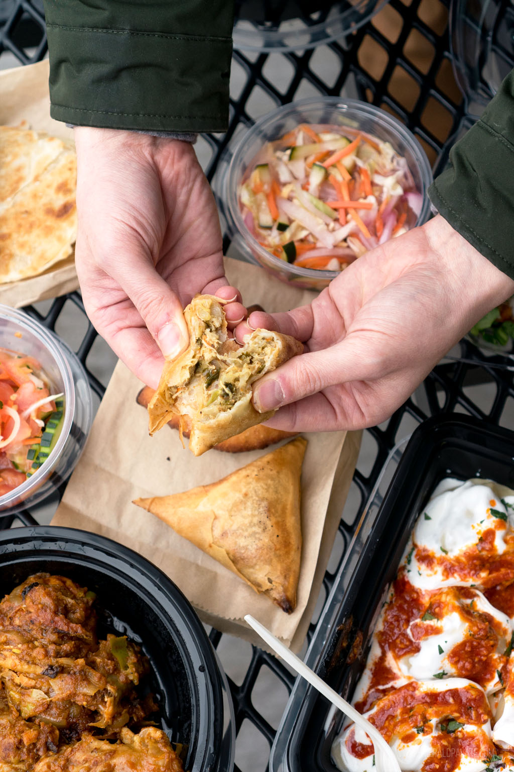 person breaking a samosa from a place for lunch in Seattle