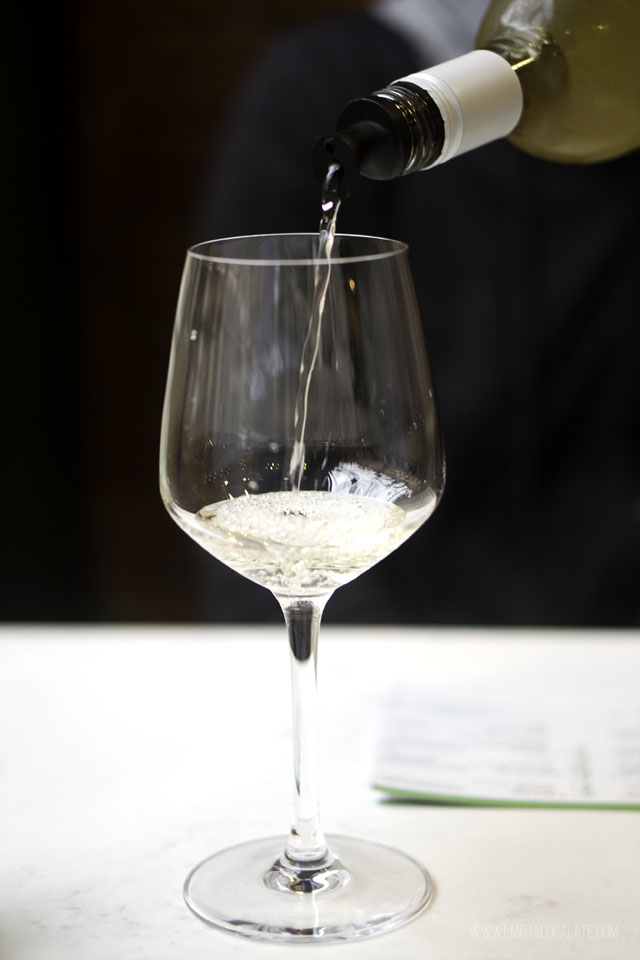 wine being pour into a wine glass at one of the best Seattle wine stores - Champion Wine Cellars