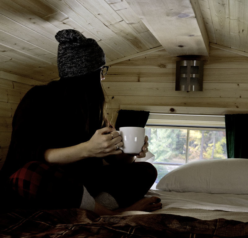 woman sitting on bed in one of the cool places to stay in Seattle