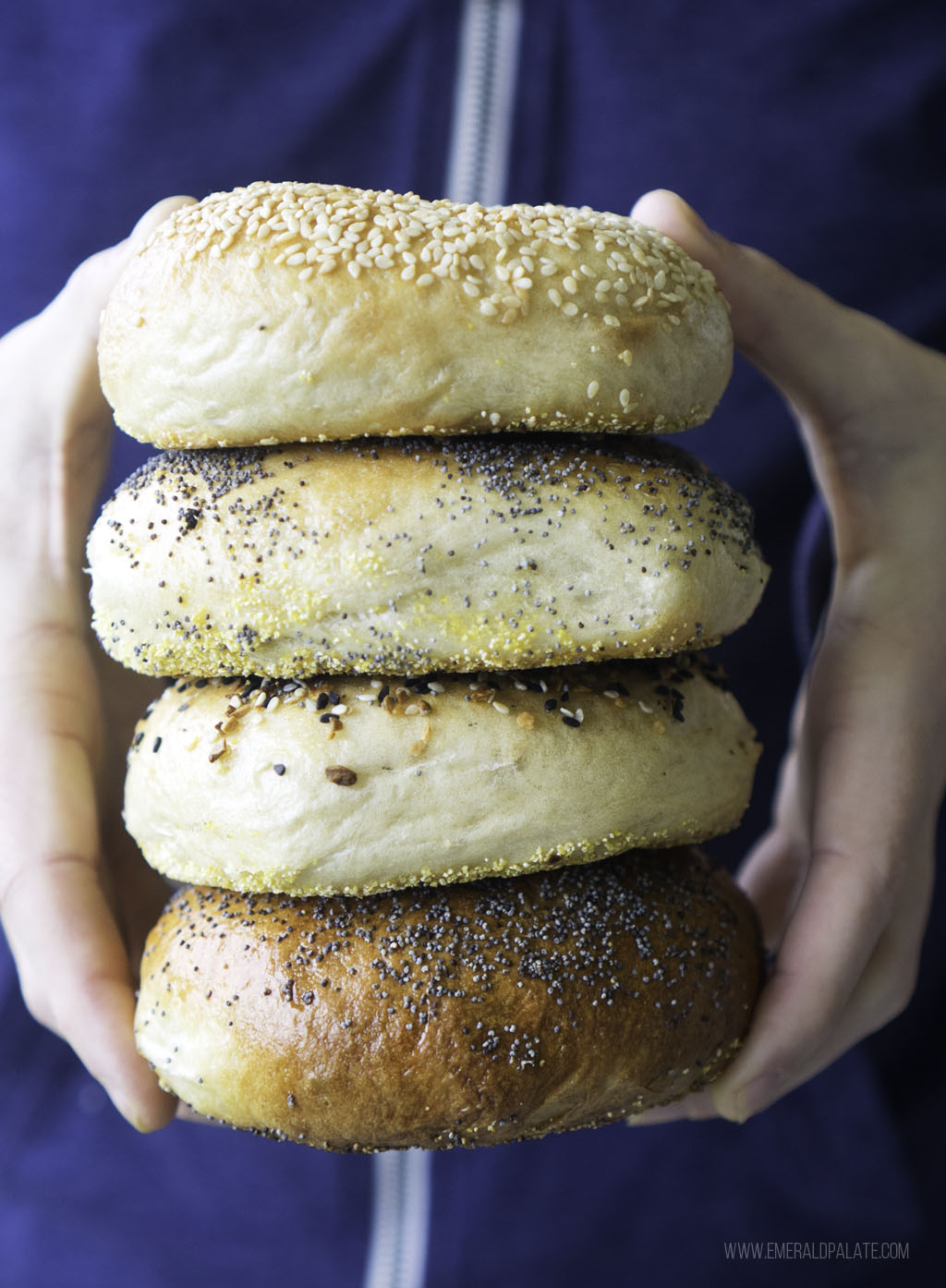 person holding stack of 4 Seattle bagels