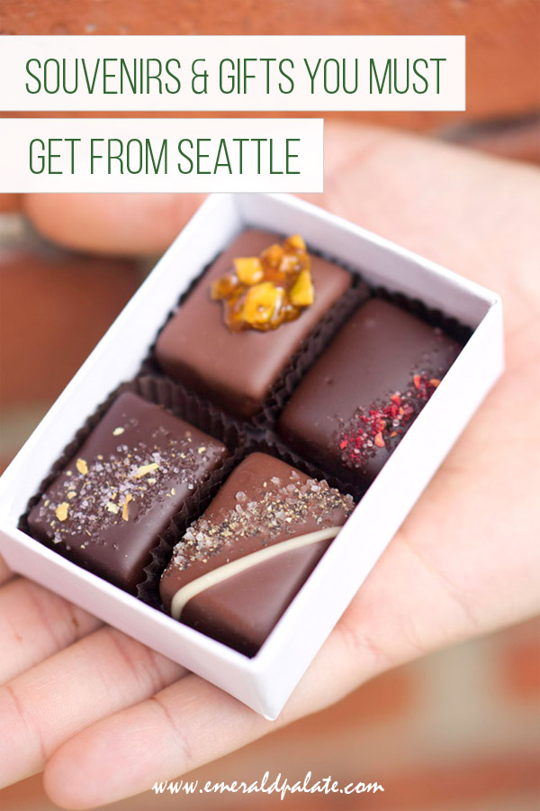 person holding a box of 4 chocolate confections with text over it that says souvenirs an gifts you must get from Seattle