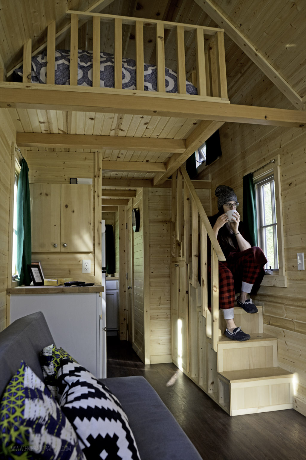 Woman sitting on steps inside a tiny home at one of the best glamping spots in Washington state