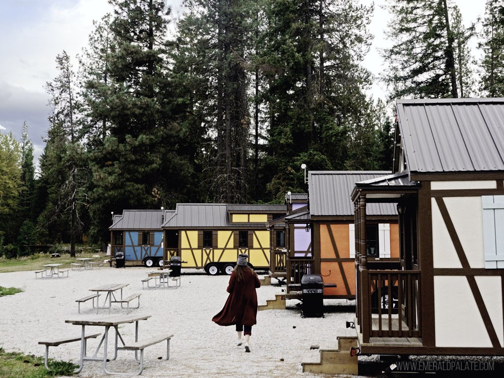 woman running through colorful tiny homes that are some of the best Leavenworth cabins