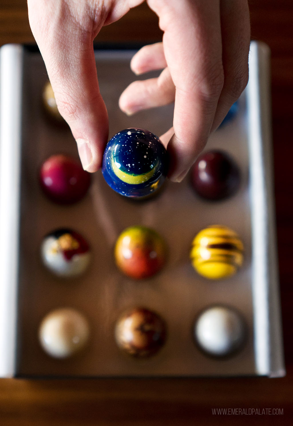 person holding a blue bonbon with a moon and stars painted on it