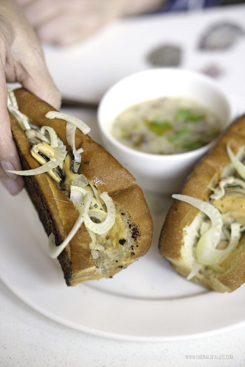 person holding a grilled mussel roll at one of the best seafood restaurants in Seattel