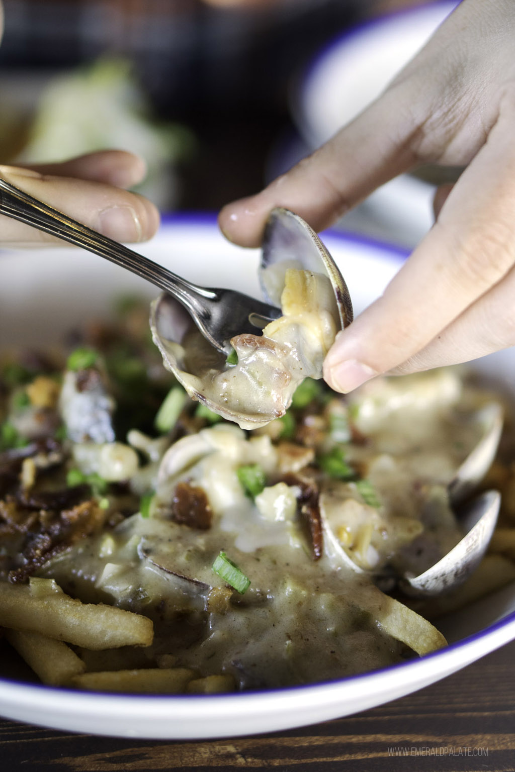 person picking clam out of shell at one of the best restaurants in South Lake Union