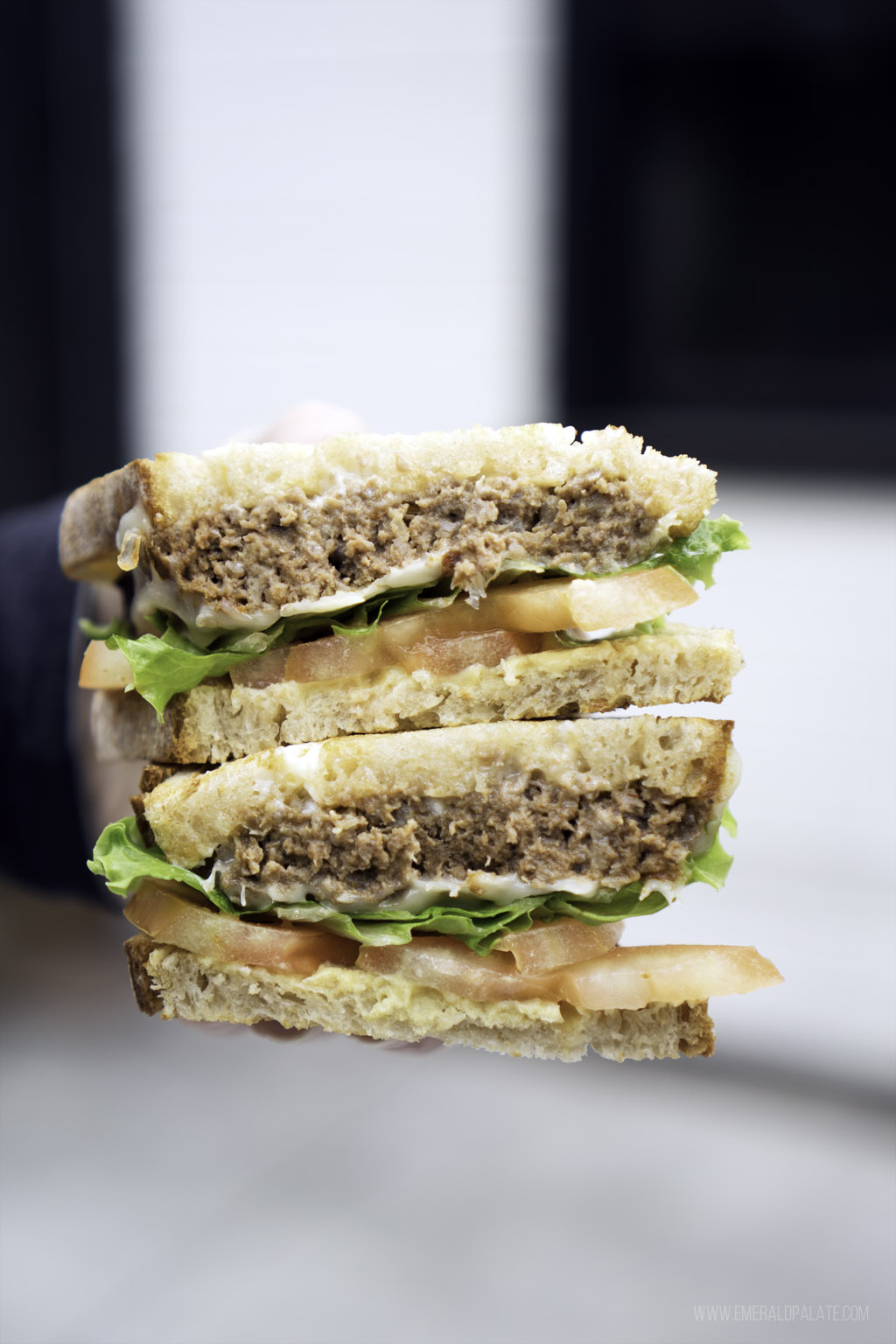 person holding stacks of a meatloaf sandwich at one of the best restaurants in Skagit County, Washington