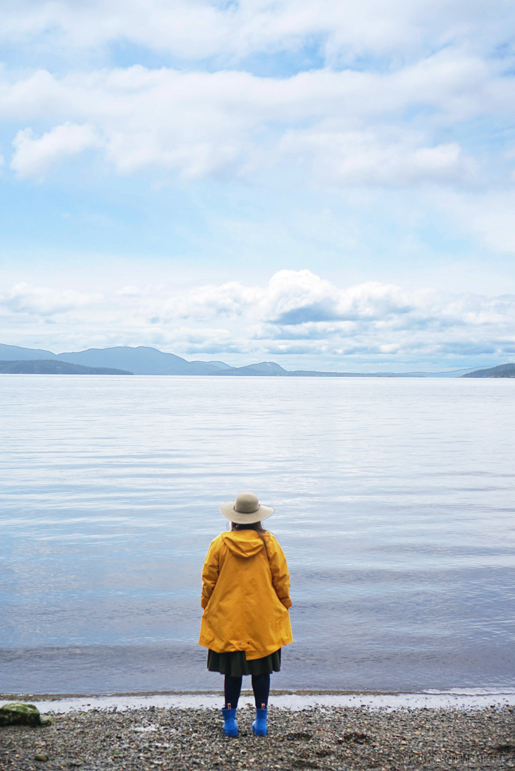 woman on beach looking out at Puget Sound and water views