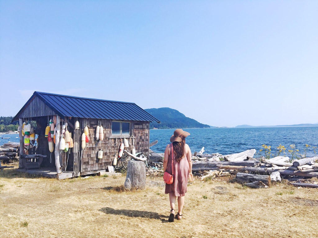 woman looking out of water near buoy house on Lummi Island, one of the best islands near Seattle